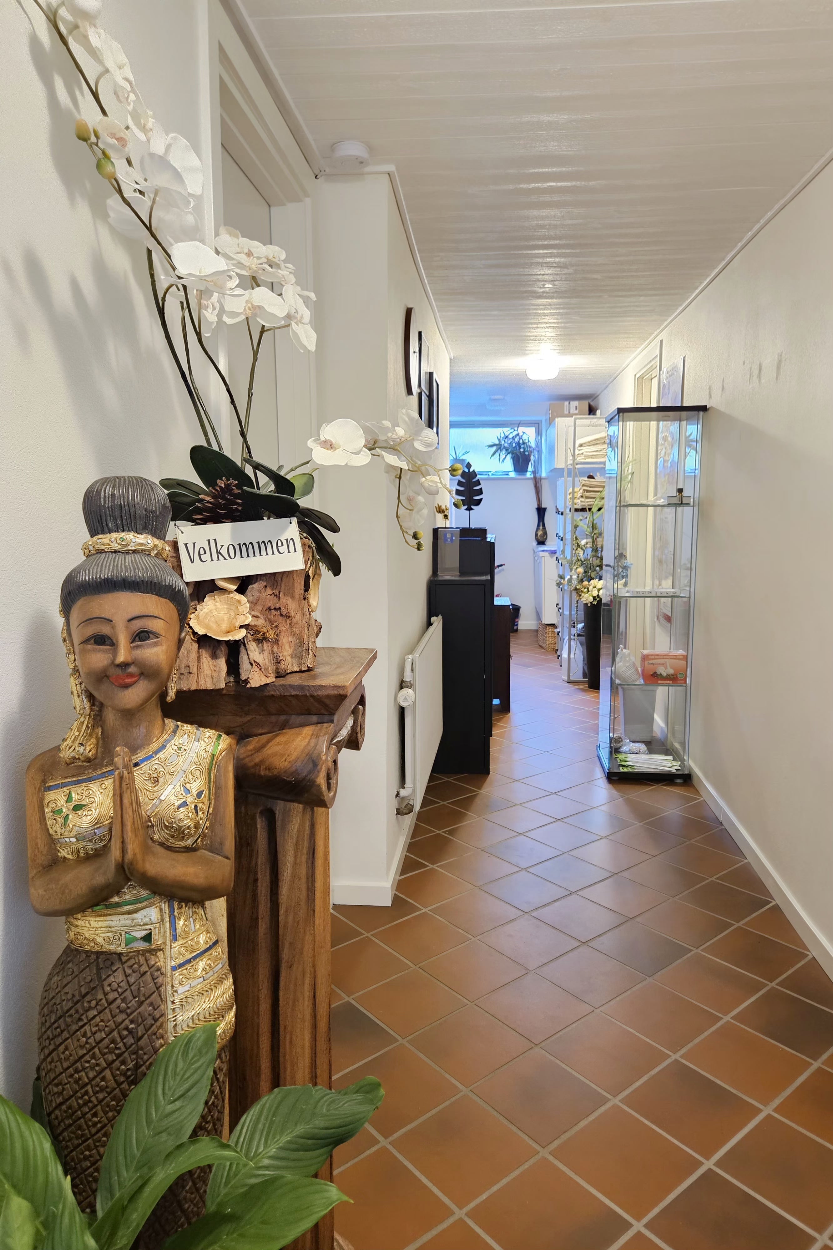 Et billede af en kvindefigur, der giver en velkomstgest.